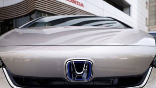 The Honda Motor Co. badge on a Fit e:HEV vehicle displayed outside a showroom at the company's headquarters in Tokyo, Japan.