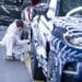 An employee works on a wheel arch of an Aston Martin sport utility vehicle.