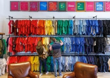 Shoppers browse colorful shirts at a clothing store