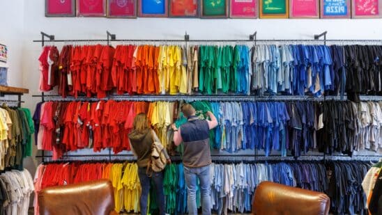 Shoppers browse colorful shirts at a clothing store