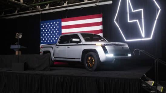 An image of Lordstown Motor's Endurance pickup truck on a stage with an American flag behind it.