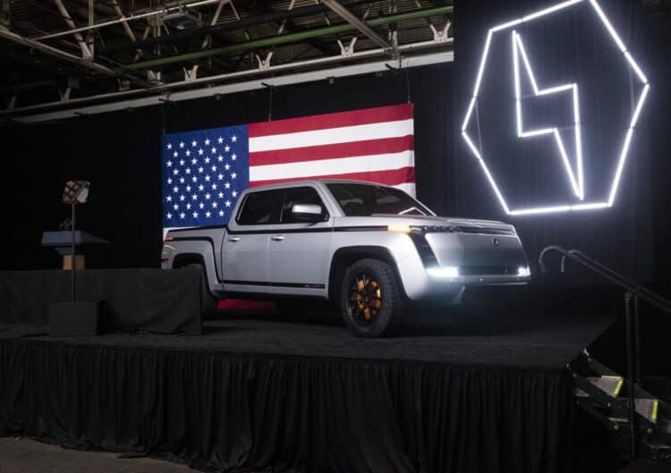 An image of Lordstown Motor's Endurance pickup truck on a stage with an American flag behind it.