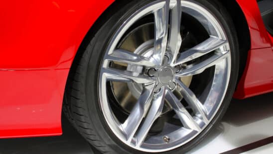 Silver rim and tire of a red car