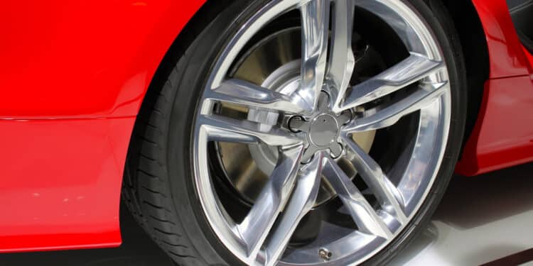Silver rim and tire of a red car
