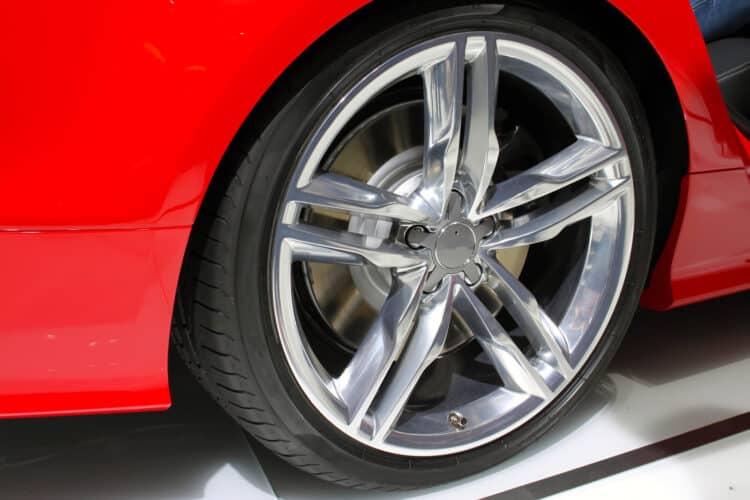 Silver rim and tire of a red car