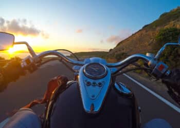 Biker riding a classic motorcycle at sunset