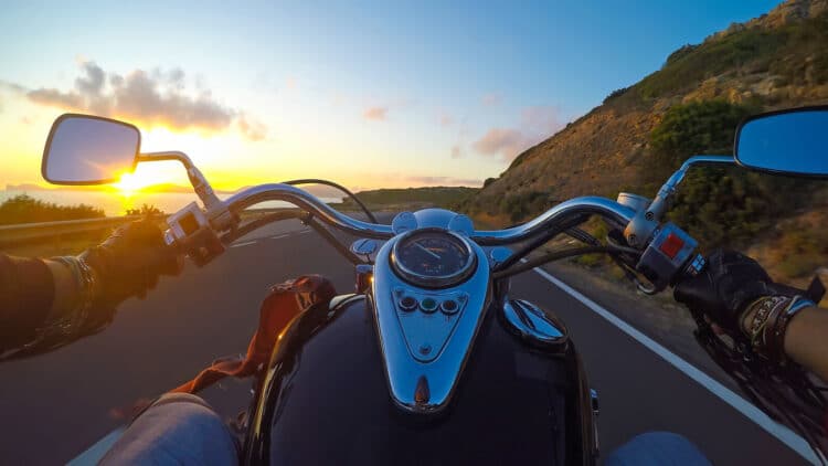Biker riding a classic motorcycle at sunset