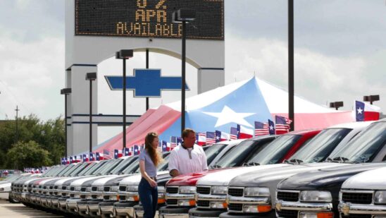 Two people looking at a car in a sales lot in Texas