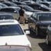 A car dealer walks past cars for sale at a used car dealership in Jersey City, New Jersey, U.S, on Wednesday, May 20, 2020. Governor Phil Murphy has lifted restrictions on in-person auto sales, provided the businesses follow social distancing guidelines, NBC reported.