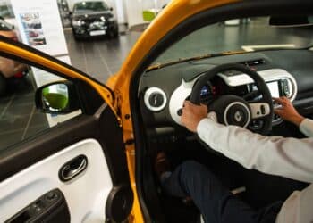 An employee in the driver's seat of a Renault Twingo E-Tech electric automobile at a Renault SA showroom