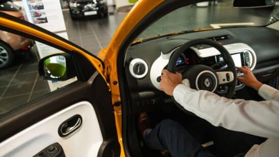 An employee in the driver's seat of a Renault Twingo E-Tech electric automobile at a Renault SA showroom