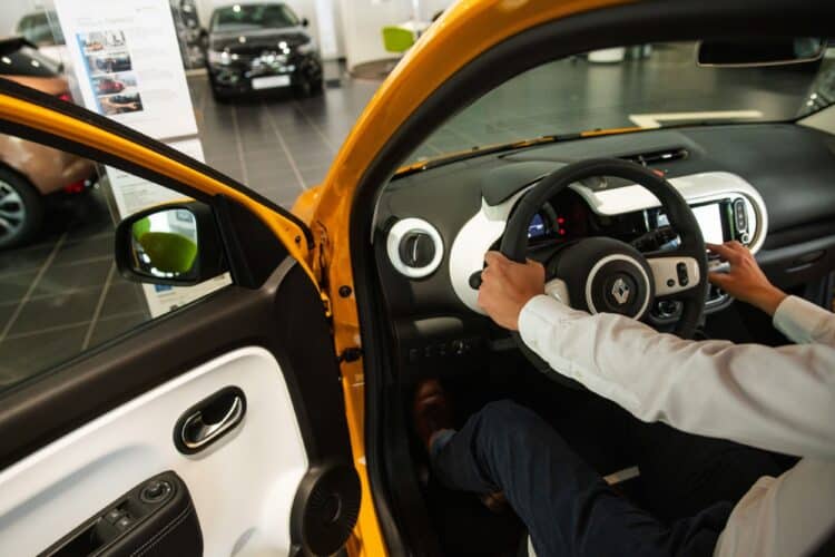 An employee in the driver's seat of a Renault Twingo E-Tech electric automobile at a Renault SA showroom