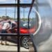 A person looks at a vehicle displayed for sale at a car dealership