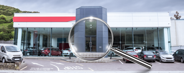 dealership with magnifying glass in front