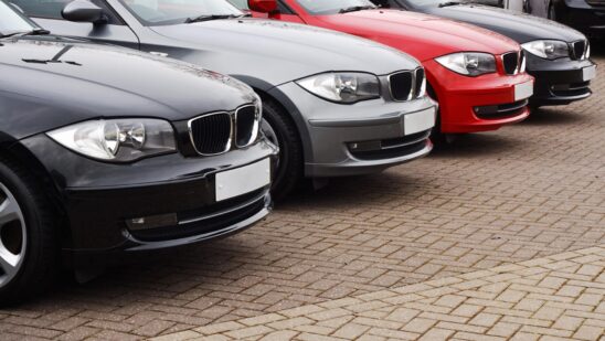Row of prestige used cars for retail sale in a motor dealers yard