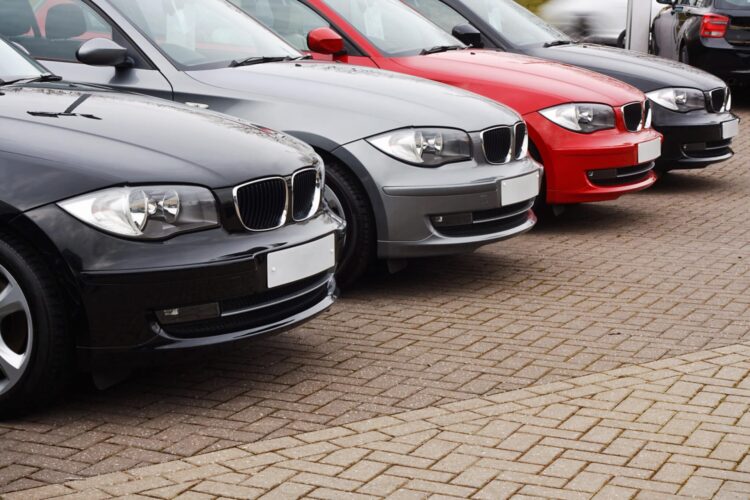 Row of prestige used cars for retail sale in a motor dealers yard