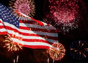 Fireworks going off behind an American flag