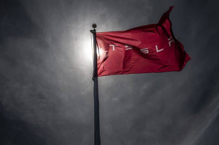 A Tesla branded flag outside a dealership in Corte Madera, California, US, on Thursday, March 2, 2023. Tesla Inc.'s much-awaited investor day failed to live up to the hype, and the shares of the electric vehicle maker are paying the price. Photographer: David Paul Morris/Bloomberg