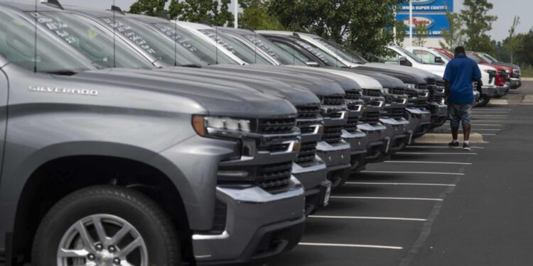 A customer looks over General Motors Co. Chevrolet vehicles displayed for sale at a car dealership in Grove City, Ohio, U.S., on Saturday, Aug. 15, 2020. Sport-utility vehicles and trucks are dominating U.S. auto sales like never before as carmakers start to recover from the biggest shock to their industry in decades.