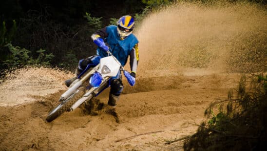 Bike rider in action turning on sand terrain.
