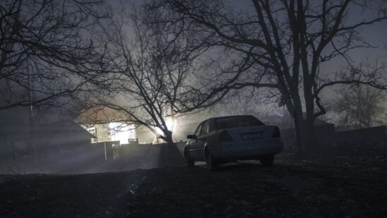 Silhouette of car and trees at night forest with fog, surreal lights mystical landscape