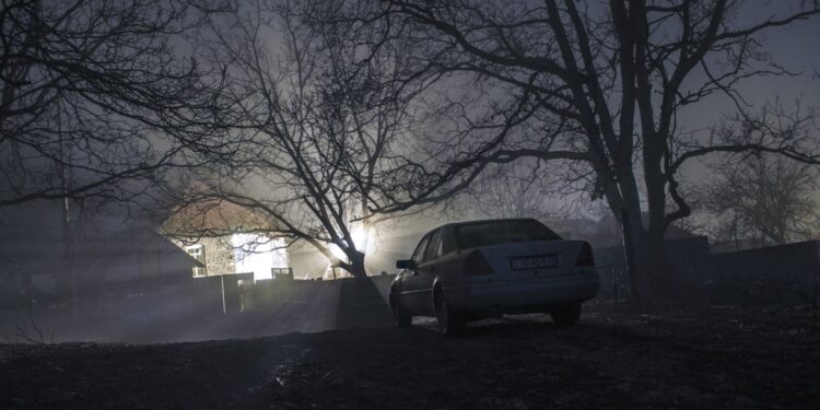 Silhouette of car and trees at night forest with fog, surreal lights mystical landscape