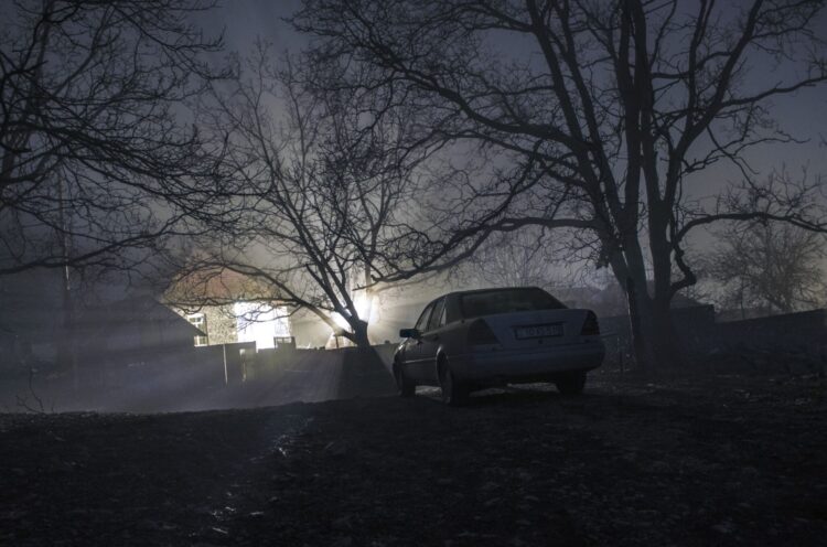 Silhouette of car and trees at night forest with fog, surreal lights mystical landscape