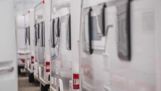 Lines of brand new travel trailers. recreational vehicles sale. rv dealer lot. industrial theme.