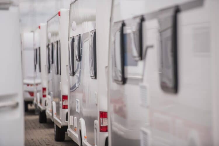 Lines of brand new travel trailers. recreational vehicles sale. rv dealer lot. industrial theme.
