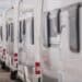 Lines of brand new travel trailers. recreational vehicles sale. rv dealer lot. industrial theme.