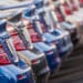 Selection of new metallic blue and gray cars lined up in dealership parking lot.