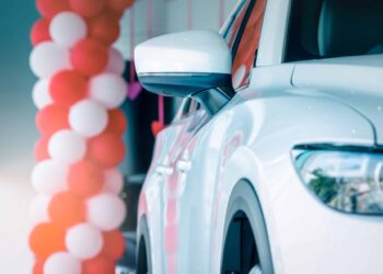 Side mirror white car parked in modern showroom