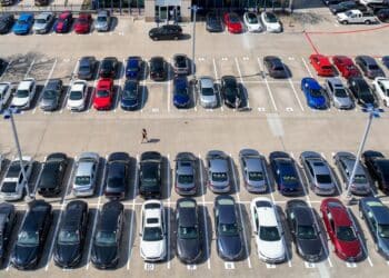 a customer walks through a Carmax dealership