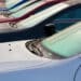 Cars on a dealer lot with dew on the windshield