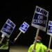 Factory workers and UAW union members form a picket line on Oct. 12.