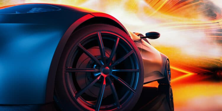 Close up of a car front tire with a red and yellow lights behind it