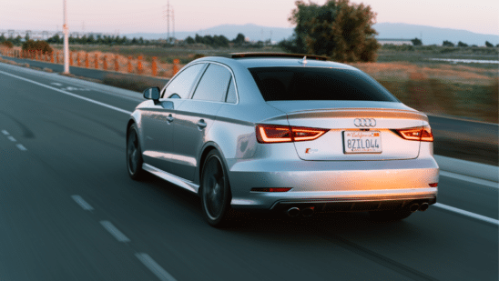 Car driving lit up by the sunset