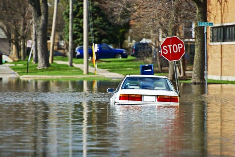 car in flood waters by stop sign