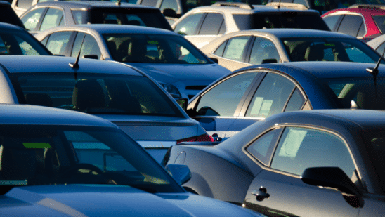 cars in lot with sunrise in back