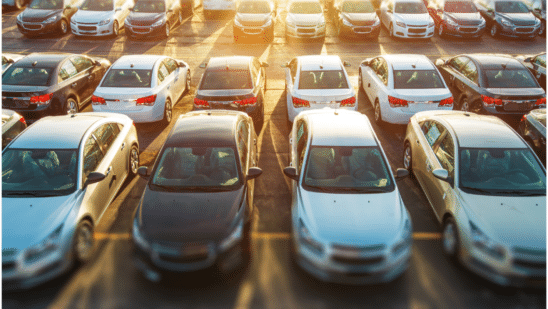 cars lined up on lot at sunset