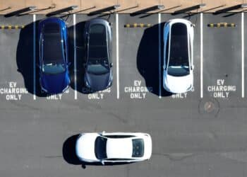 In an aerial view, Tesla cars recharge at a Tesla charger station
