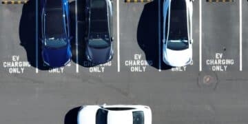 In an aerial view, Tesla cars recharge at a Tesla charger station