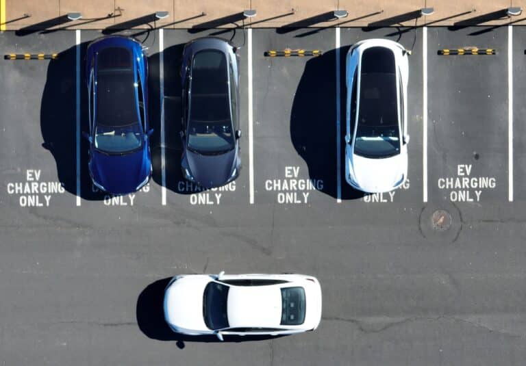 In an aerial view, Tesla cars recharge at a Tesla charger station