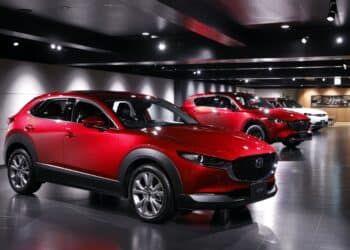 A Mazda Motor Corp. CX-30 crossover sport utility vehicle (SUV), left, displayed at the company's museum in Fuchu Town, Hiroshima Prefecture, Japan, on Wednesday, June 15, 2022. To ease the impact of inflation, Prime Minister Fumio Kishida put together a series of relief measures including bigger gasoline subsidies. Photographer: Kiyoshi Ota/Bloomberg