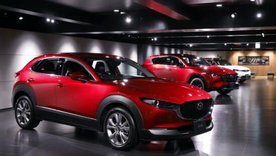 A Mazda Motor Corp. CX-30 crossover sport utility vehicle (SUV), left, displayed at the company's museum in Fuchu Town, Hiroshima Prefecture, Japan, on Wednesday, June 15, 2022. To ease the impact of inflation, Prime Minister Fumio Kishida put together a series of relief measures including bigger gasoline subsidies. Photographer: Kiyoshi Ota/Bloomberg