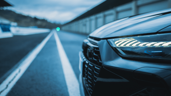 Side close up of car headlight and grill