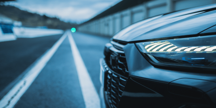 Side close up of car headlight and grill