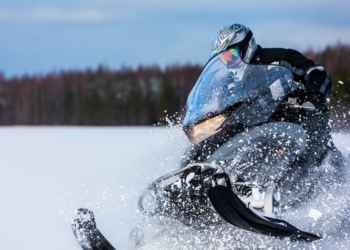 Snowmobile rider riding through the snow