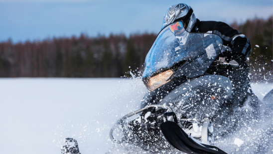 Snowmobile rider riding through the snow