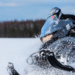 Snowmobile rider riding through the snow